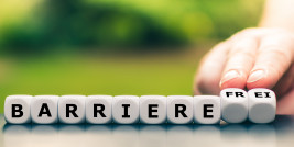 Fokussiert / stock.adobe.com Hand dreht Würfel und ändert das Wort Barriere in barrierefrei